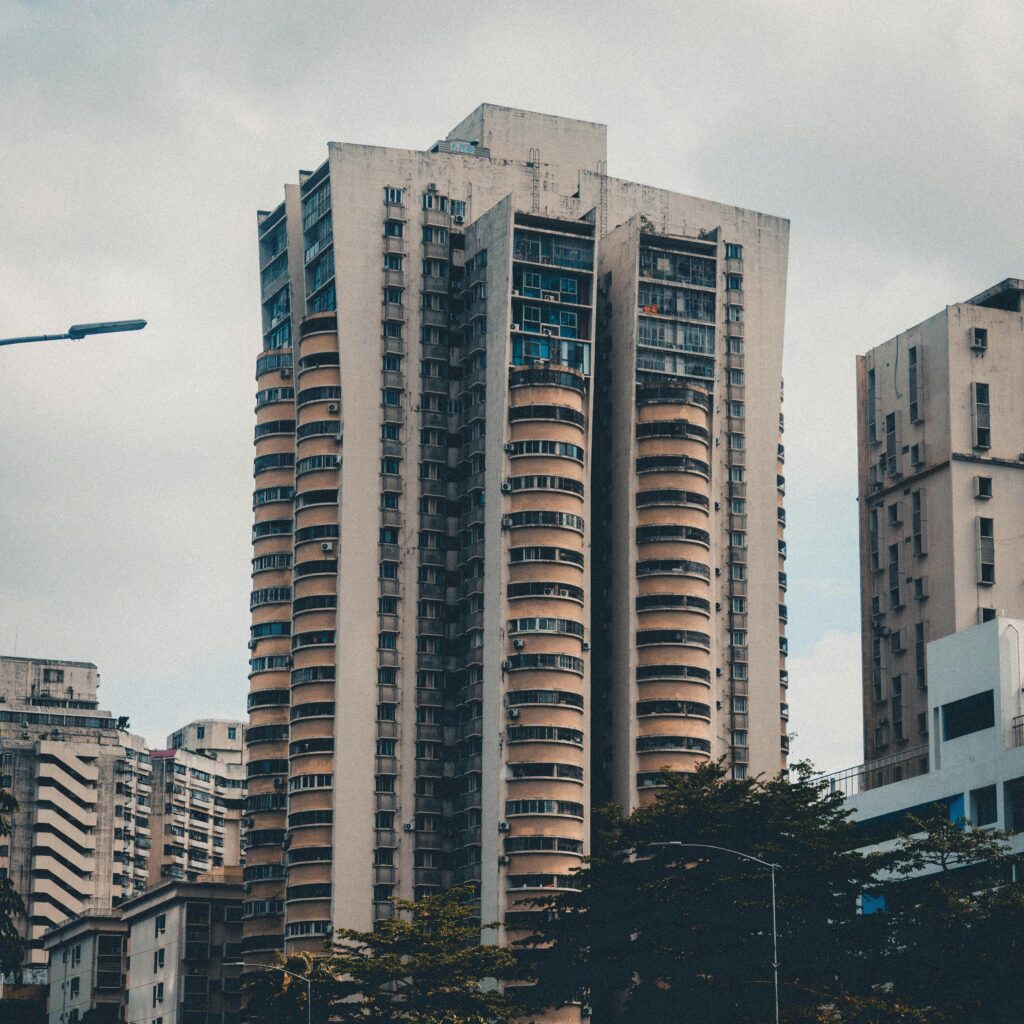 Tall residential high-rise buildings in a city under cloudy sky, showcasing urban architecture.