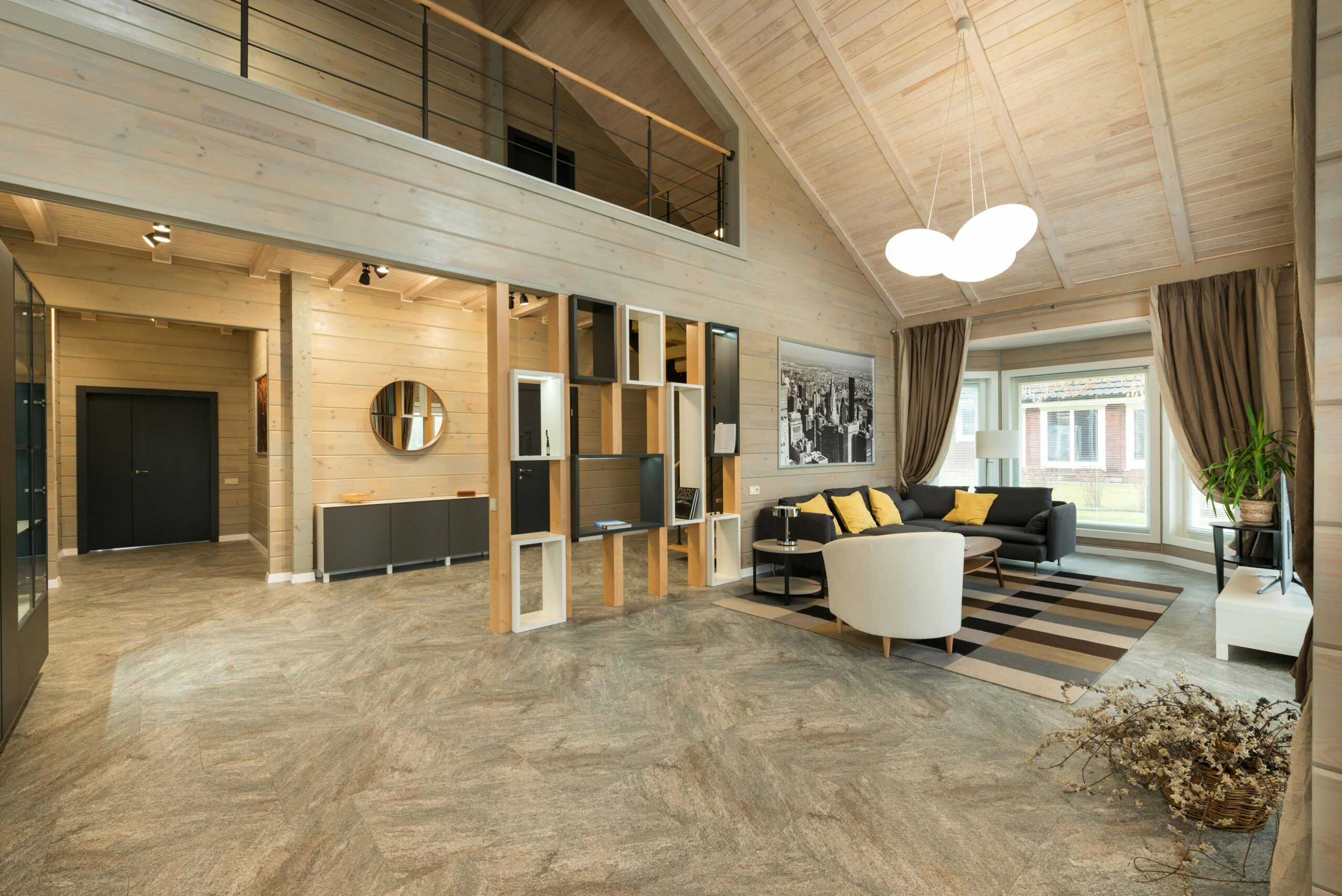 Interior of stylish spacious cottage with sofa under lamps in living zone and corridor at entrance of big cottage